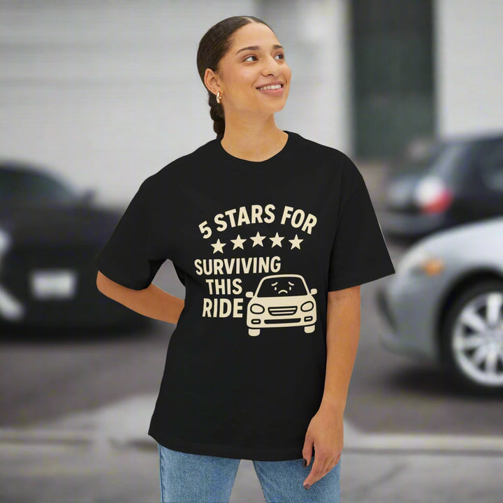 Person wearing a black t-shirt with humorous text design on a white background that says 5 stars for surviving this ride.