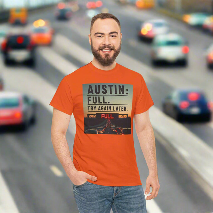 Man wearing an orange t-shirt with a graphic design on a white background with text Austin Full. Try again later