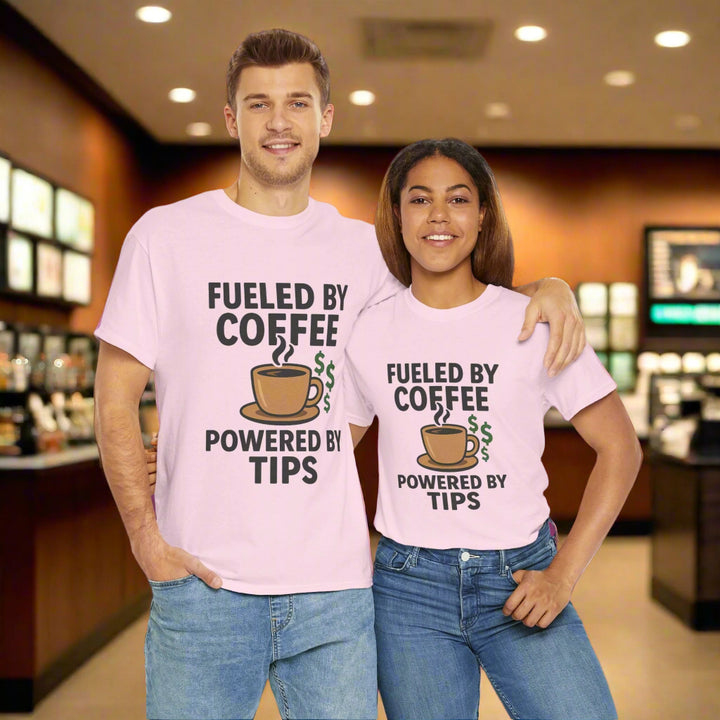 Two people wearing pink t-shirts with a coffee-themed design with the text fueled by coffee powered by tips on a white background